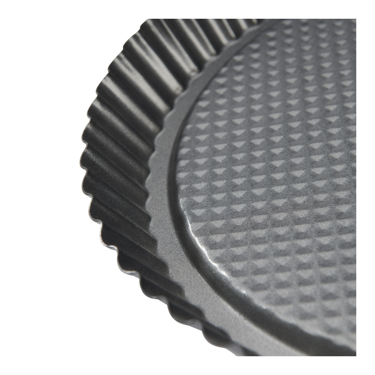 Close-up of a dark gray fluted round tart or cake pan with a textured non-stick surface.