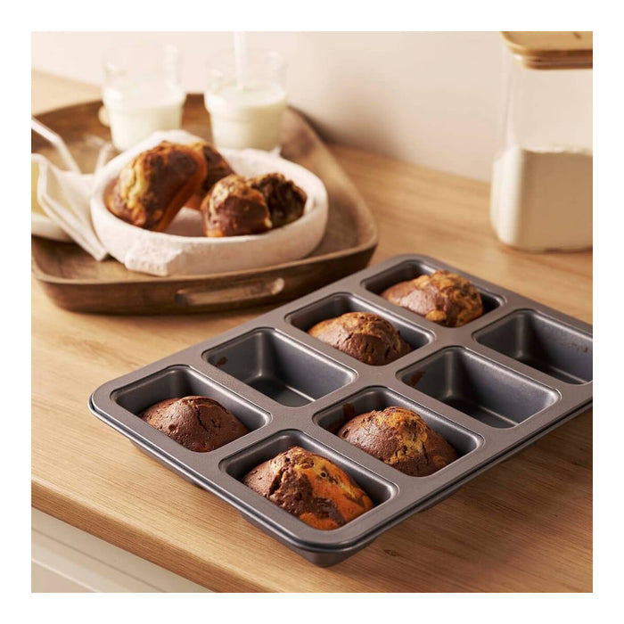 Eight individual mini cakes baked in a rectangular multi-cavity tray